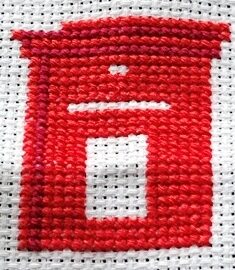 Two tones of red stitching in the mini cross stitch kit of a pillar post box.