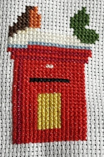 The finished cross stitched holly leaves.